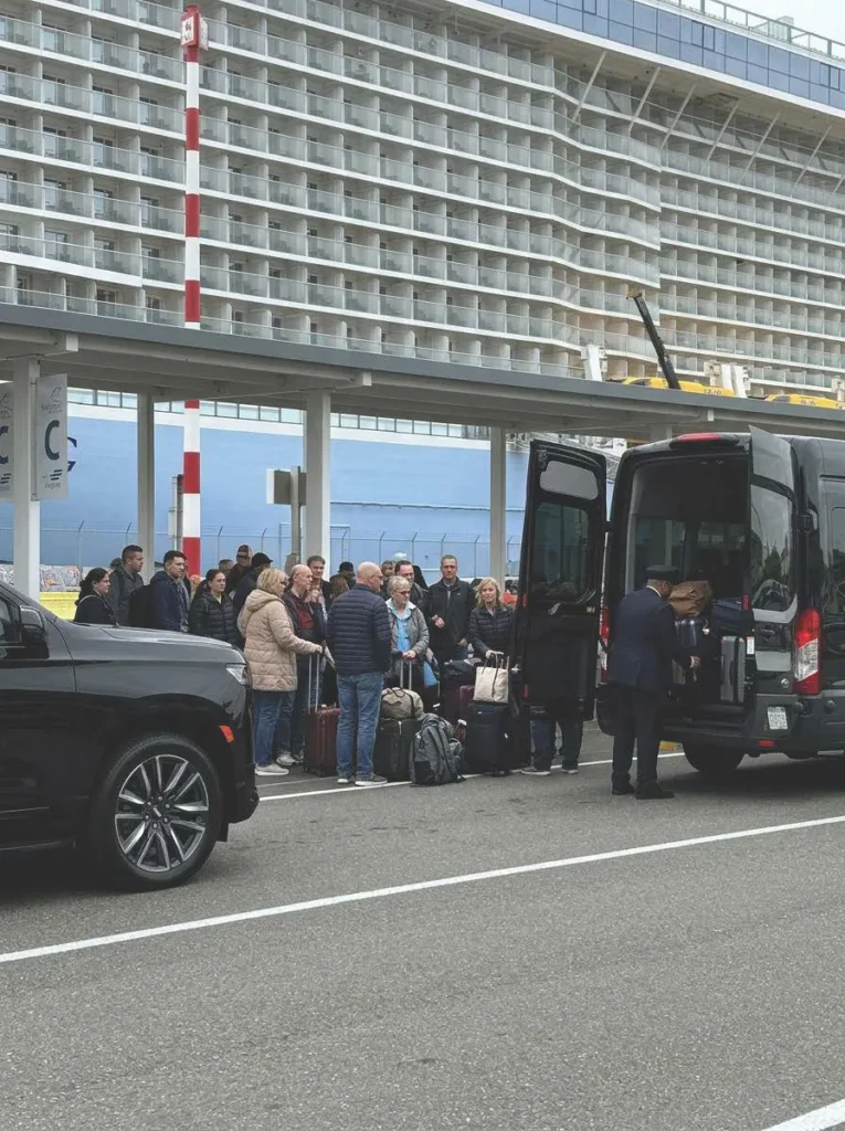 Chauffeur loading luggage into a black van at the cruise terminal